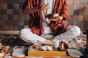 Tibetan singing bowl in the hands of a man during a tea ceremony photo