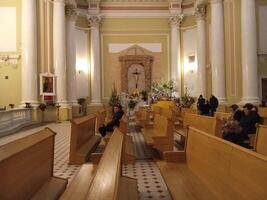 Sankt Petersburgo Rusia - 01 01 2024 católico hombres y mujer arrodillarse y orar dentro el catedral foto