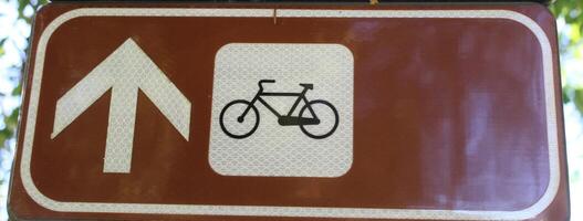 Close-up of cycle icon on a brown background. The symbol indicates a street or lane dedicated to cyclists photo