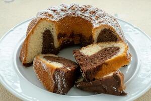 Traditional homemade marble cake. Sliced marble bundt cake on white plate photo