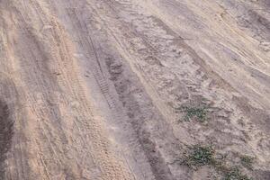 dusty dirt road at summer day, full-frame closeup view photo