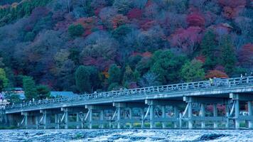 un' crepuscolo lasso di tempo di togetsukyo ponte nel kyoto nel autunno teleobiettivo tiro Ingrandisci video