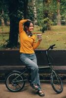 Happy young Asian woman while riding a bicycle in a city park. She smiled using the bicycle of transportation. Environmentally friendly concept. photo