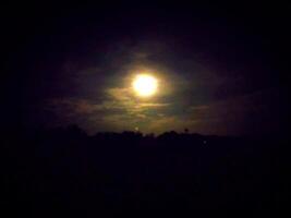 the moon is shining brightly in the dark sky photo
