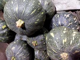 a pile of squash with green and black spots photo