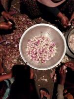 a group of people sitting around a bowl of onions photo