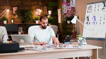 Beau barbe Jeune creativ réalisateur travail sur le sien projet dans le bureau. Créatif lieu de travail. video