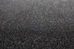 Black foam rubber. Closeup full-frame macro background with selective focus and shallow depth of field. photo