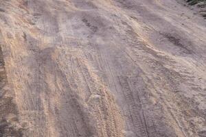 dusty dirt road at summer day, full-frame closeup view photo