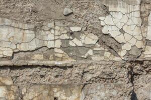 cracked white concrete wall under direct sun light full frame background and texture photo