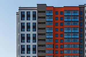 nuevo edificio de apartamentos de gran altura con múltiples balcones y ventanas en el cielo azul con fondo de nubes blancas foto