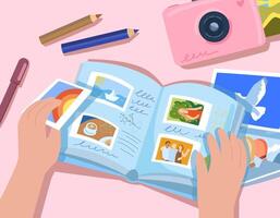 Hands hold a photo album and put photographs into it. There is an album, a camera, pencils and photographs on the table. Album of happy memories, immortalizing moments of vacation and vacation photos vector