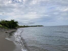 Small warm waves on the sandy shore of the sea gently stroke the shore photo