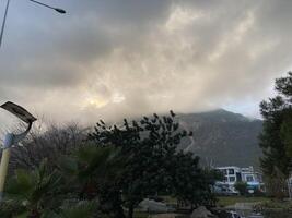 Low fluffy clouds hang over the high mountains, cover their peaks photo