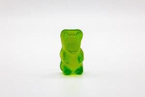 Single Green Gummy Bear Candy on White Background photo