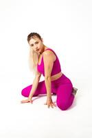 Woman in vibrant pink sports outfit both knees and hands on floor photo