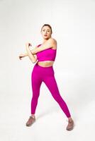 Woman in vibrant pink sports outfit with arms crossed photo