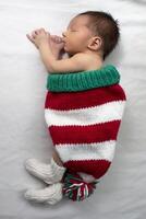 Newborn baby wearing a Christmas knitted gnome hat. photo