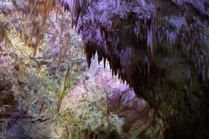 karst cueva, increíble ver de estalactitas y estalagnitas en vistoso brillante luz, hermosa natural punto de referencia en turístico lugar. foto