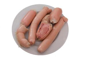 Boiled meat sausages on a plate, top view isolated on a white background. photo