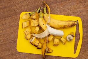 Rotten banana cut into pieces on a cutting board. photo