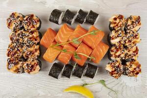 Set of various sushi rolls on a white wooden background close-up. photo