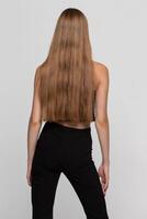 A beautiful girl shows off her beautiful long blond hair. Back view. photo