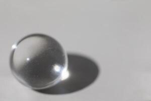 Glass ball on gray background with shadow photo