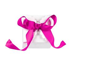 regalo caja con un rosado arco en un blanco antecedentes. foto