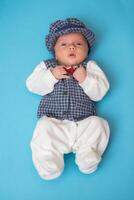 Newborn baby in vintage suit on blue background. photo