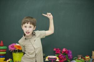 The child points to the board with his finger photo