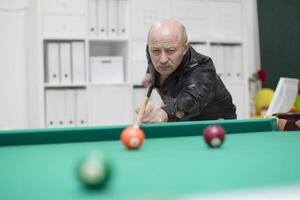 Elderly man playing billiards photo