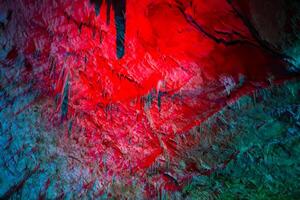 Karst cave, amazing view of stalactites and stalagnites in colorful bright light, beautiful natural landmark in touristic place. photo