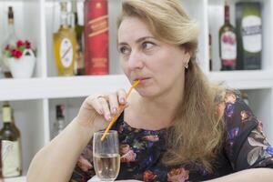 Woman drinking alcoholic cocktail from a straw photo