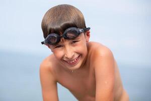 Happy child after swimming wearing swimming goggles. photo