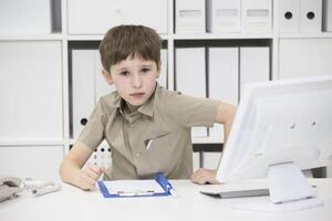 Smart schoolchild at the desk does homework photo