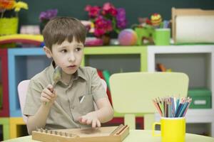 A child with a musical instrument. Boy learn to play dulcimer photo