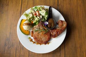 Pork Chop Steak is a pork steak that uses thigh meat or bone-in sirloin. Pork chops are soft, juicy, and have a little bit of fat. Eat with salad, mashed potatoes, and sauce. photo