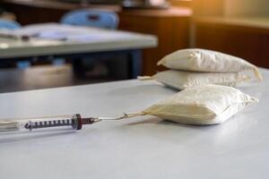 Asian students perform a physics experiment using a cylindrical Spring Balance pulling a sandbag placed on a workbench to measure the force pulling the sandbag into motion. photo