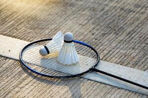 White shuttlecock 2 Placed side by side on a badminton racket with a cement background.soft and selective focus photo