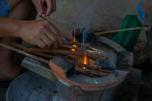 The villagers light the brazier to prepare for cooking. The brazier fire is still used in rural kitchens in the North and Northeast of Thailand. Soft and selective focus. photo