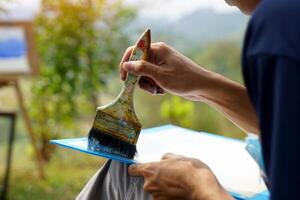 The students used paint brushes to color the distant mountain ranges from light blue to dark blue. Follow the example the teacher gives you. soft and selective focus. photo