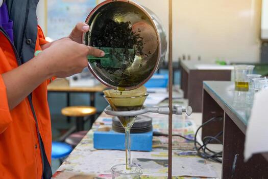 Experiment to separate mixed substances by pouring substances into a separator funnel through filter paper. Solid particles are placed on the filter paper. The liquid will flow into the beaker below. photo