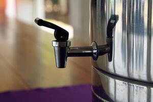 Stainless Steel Cooler Faucet To open the water, push the black plastic handle up and the water will flow into the container. To close, push it down. photo