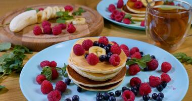 Delicious breakfast. Pancakes with raspberry, banana and a mint leaf photo