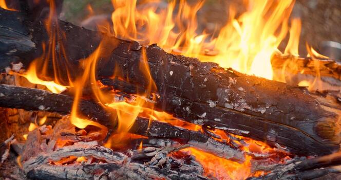 Close-up view of bonfire flames of camping fire, Slow motion burning firewood. Cozy weekend, firewood, burning logs, Heat, camping, nature outdoor recreation concept. photo