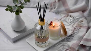 Aroma scented reed diffuser glass is on the tray with scented candle video