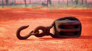 A rusty metal hook on a vibrant red dirt road video