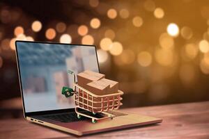 Online shopping and delivery service concept.Brown paper boxs in a shopping cart with laptop keyboard on wood table on the public park background.Easy shopping with finger tips for consumers. photo