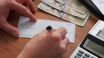 empresario mano utilizando bolígrafo para escritura en cheque concepto. un empresario haciendo algunos papeleo utilizando su calculadora foto